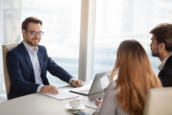 A man having a meeting in his office with a man and a woman